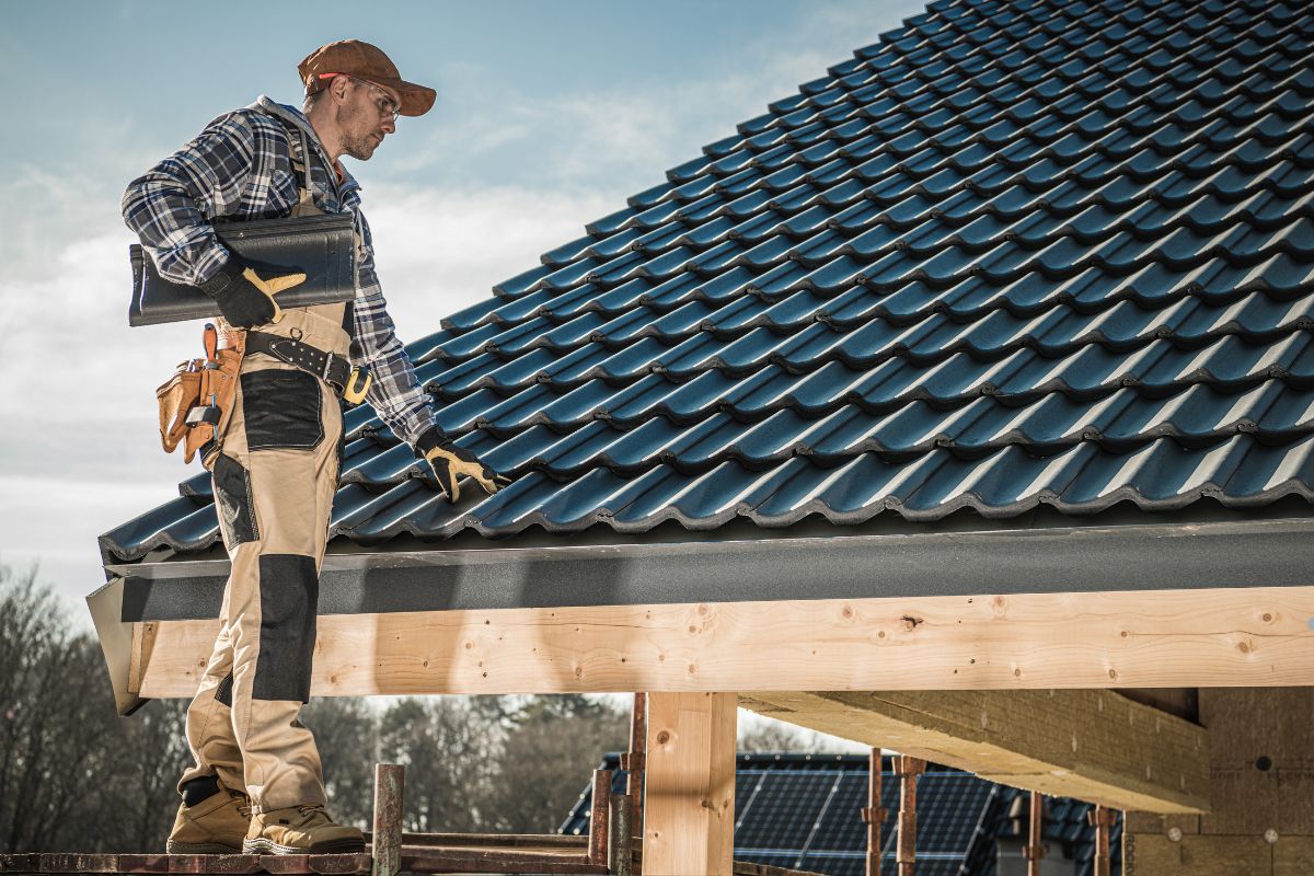 A man stands on a house roof, holding a tool, comparing roof-mounted and foldable installation methods.